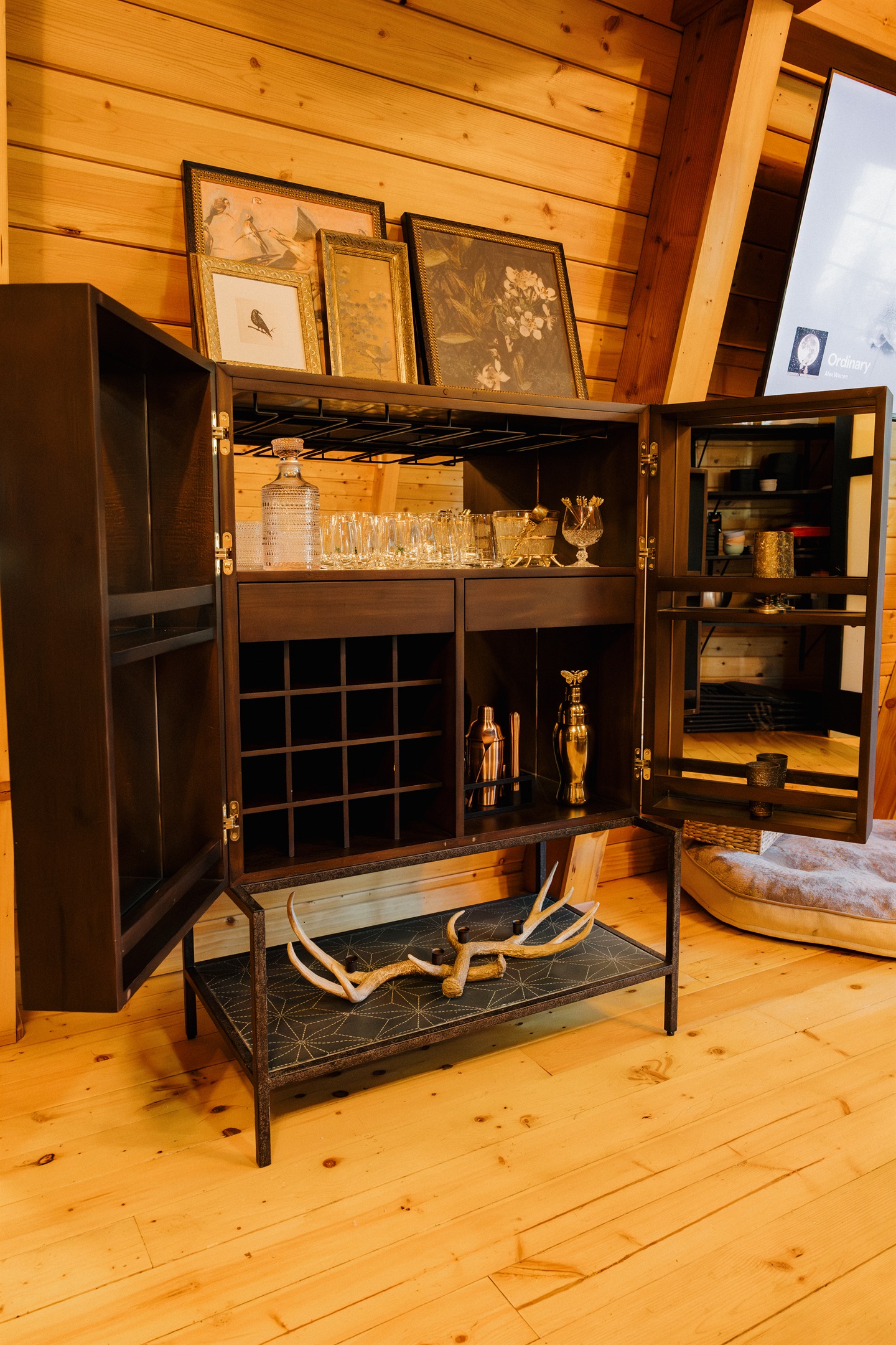 A curated bar cabinet stocked with glassware and barware awaits at Poppywood Pines. This gothic western Show Low A-frame blends luxury amenities with rustic charm, perfect for entertaining after days exploring White Mountains hiking trails and lakes.