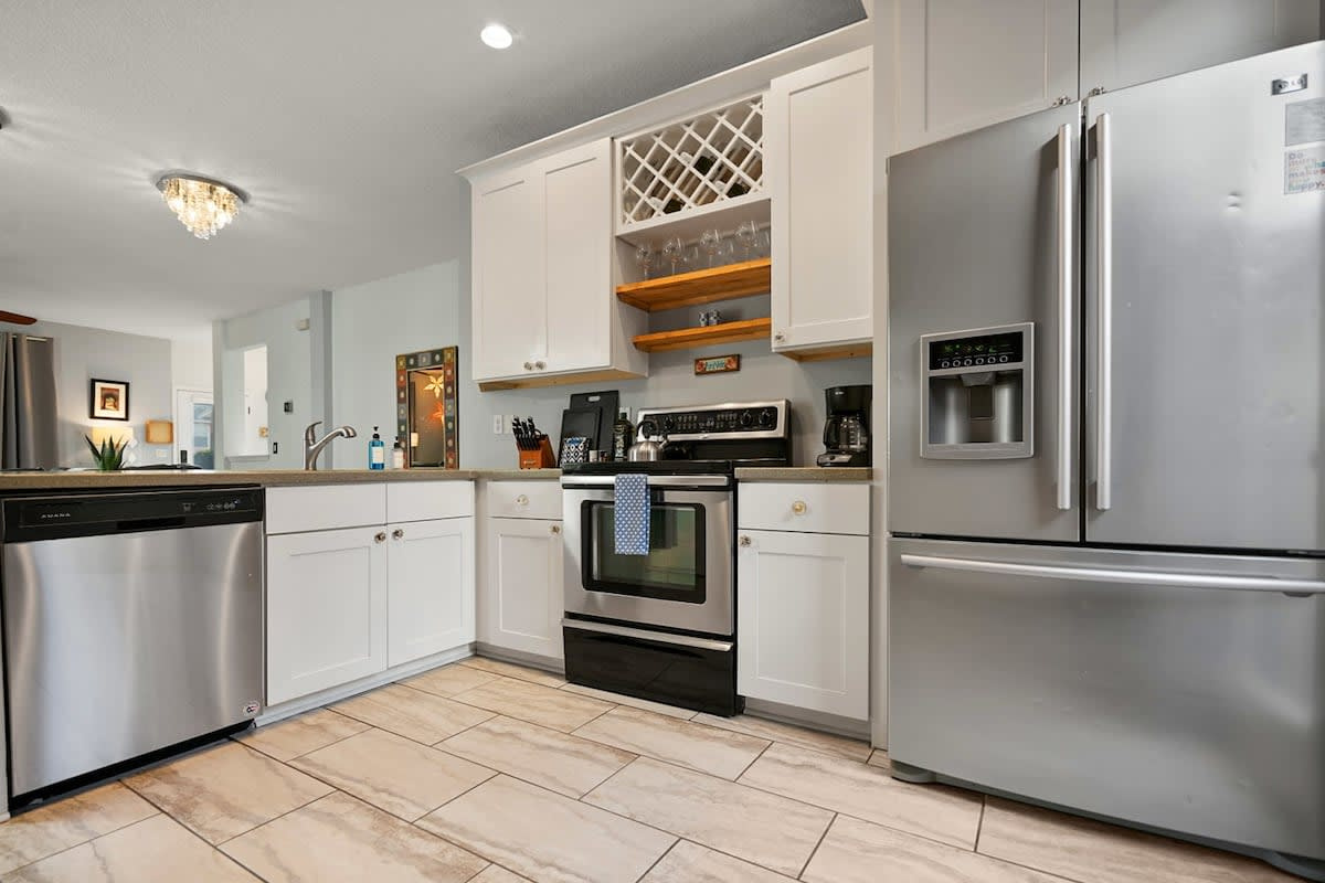 The kitchen is set up to genuinely feed ten: full-size range and oven, dishwasher, French-door refrigerator and a wine rack above. Cook properly here, or just reheat what came back from the fish counter.
