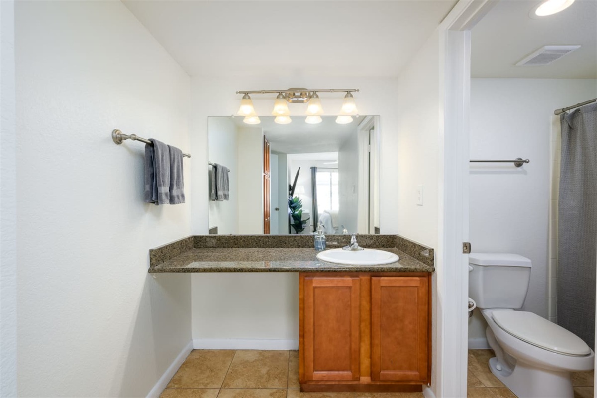 Clean bathroom setup with counter space, fresh towels, and easy access to the shower.
