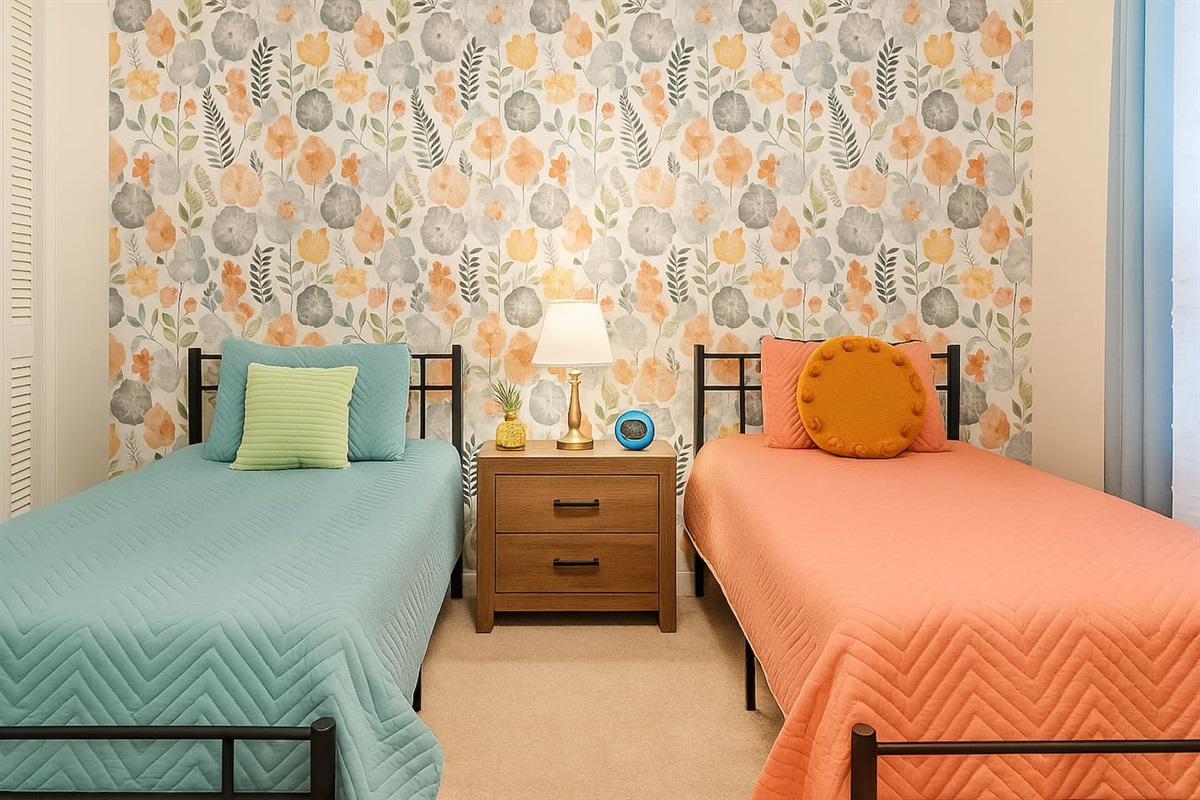 Bright twin bedroom with cheerful patterns and cozy beds — ideal for kids or extra guests needing space and comfort. 