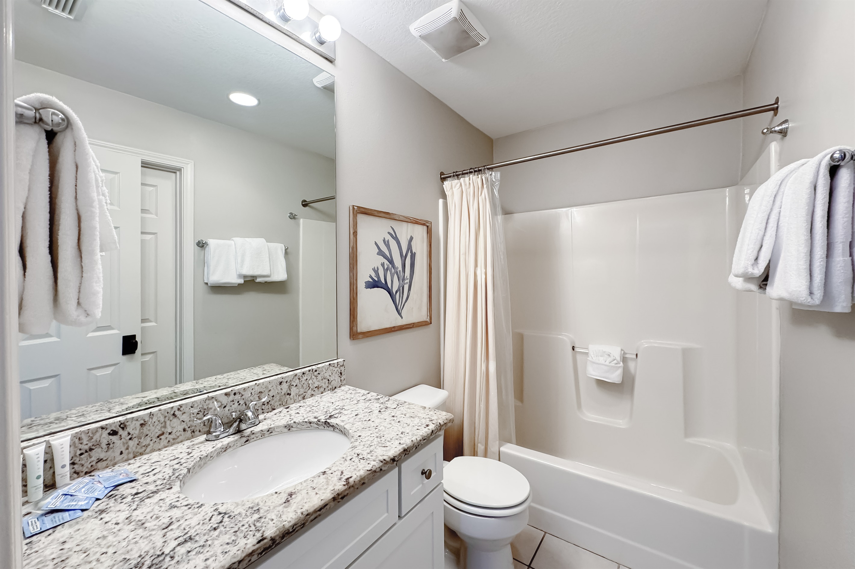 Freshly updated bathroom featuring a shower/tub combination, ample vanity space, and modern fixtures.