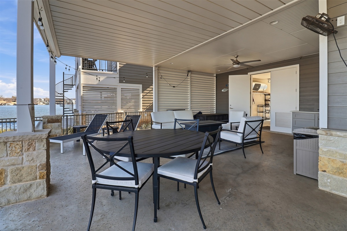 Lake level patio with lots of seating, BBQ grill, and opens to garage with ping pong table and nice cross breeze.