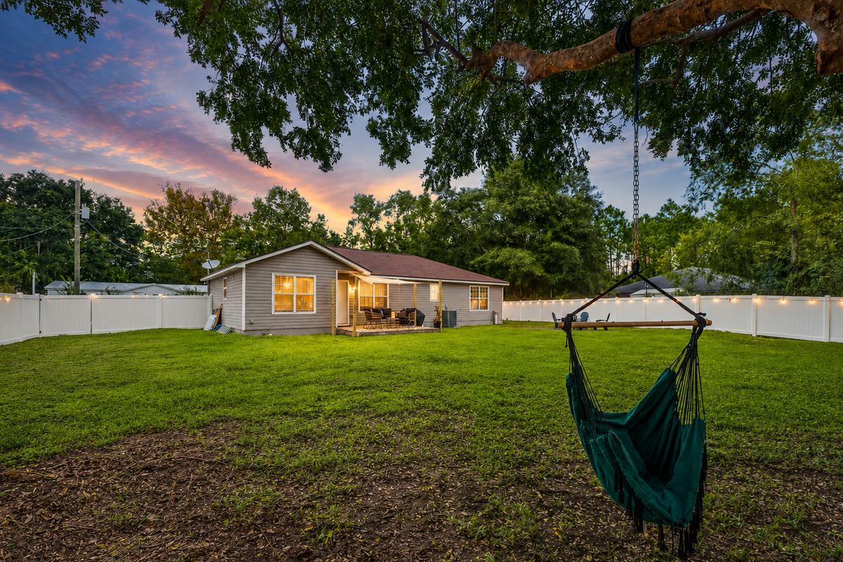 Spacious backyard with hammock chair, sunset views, and cozy patio retreat.