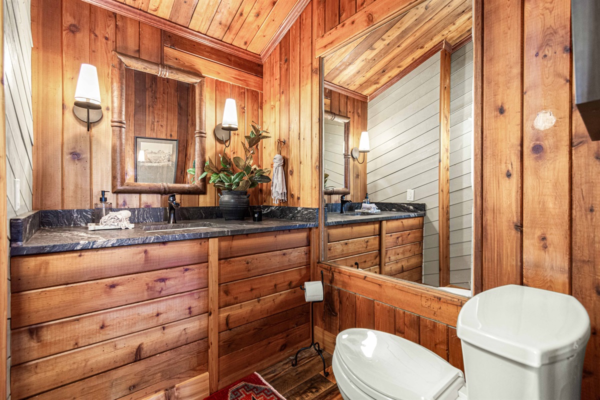 A rustic bathroom with warm wood finishes and a custom vanity, blending cabin character with everyday comfort.