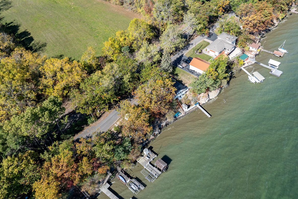 Charming lakeside cottage nestled among colorful trees and peaceful water views.