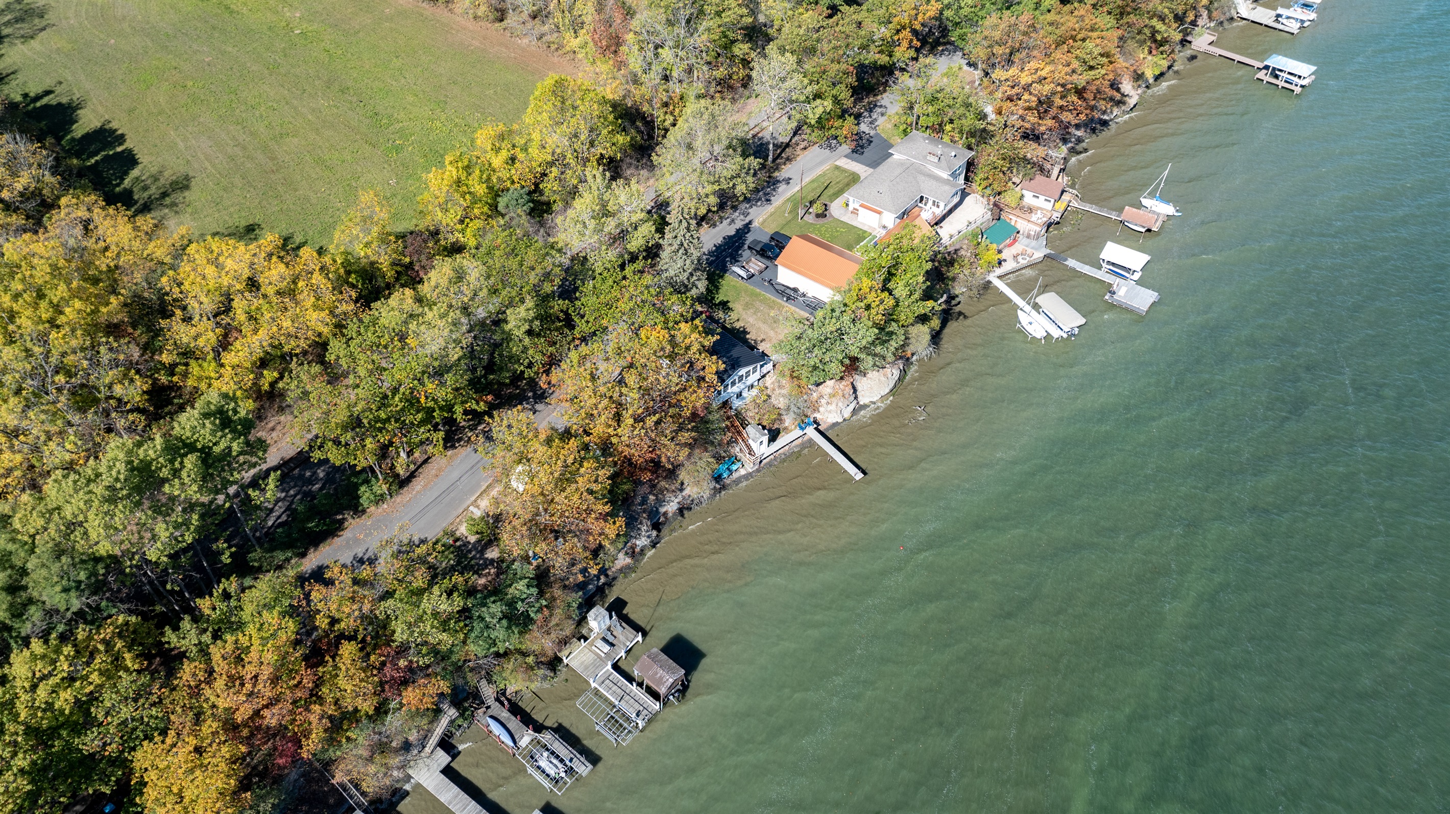 Charming lakeside cottage nestled among colorful trees and peaceful water views.