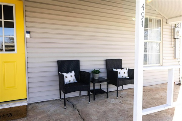 Relax on the front porch with comfortable seating, perfect for enjoying morning coffee or evening sunsets.