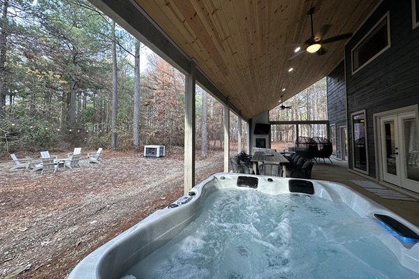 Back porch with TV, sofa, hot tub, games, and a fire pit.