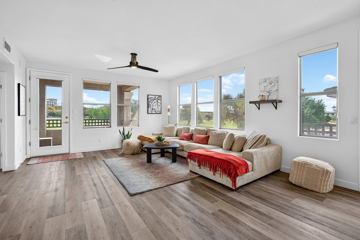 Living room with oversized sectional seating, wide windows, and open views of the desert landscaping outside.