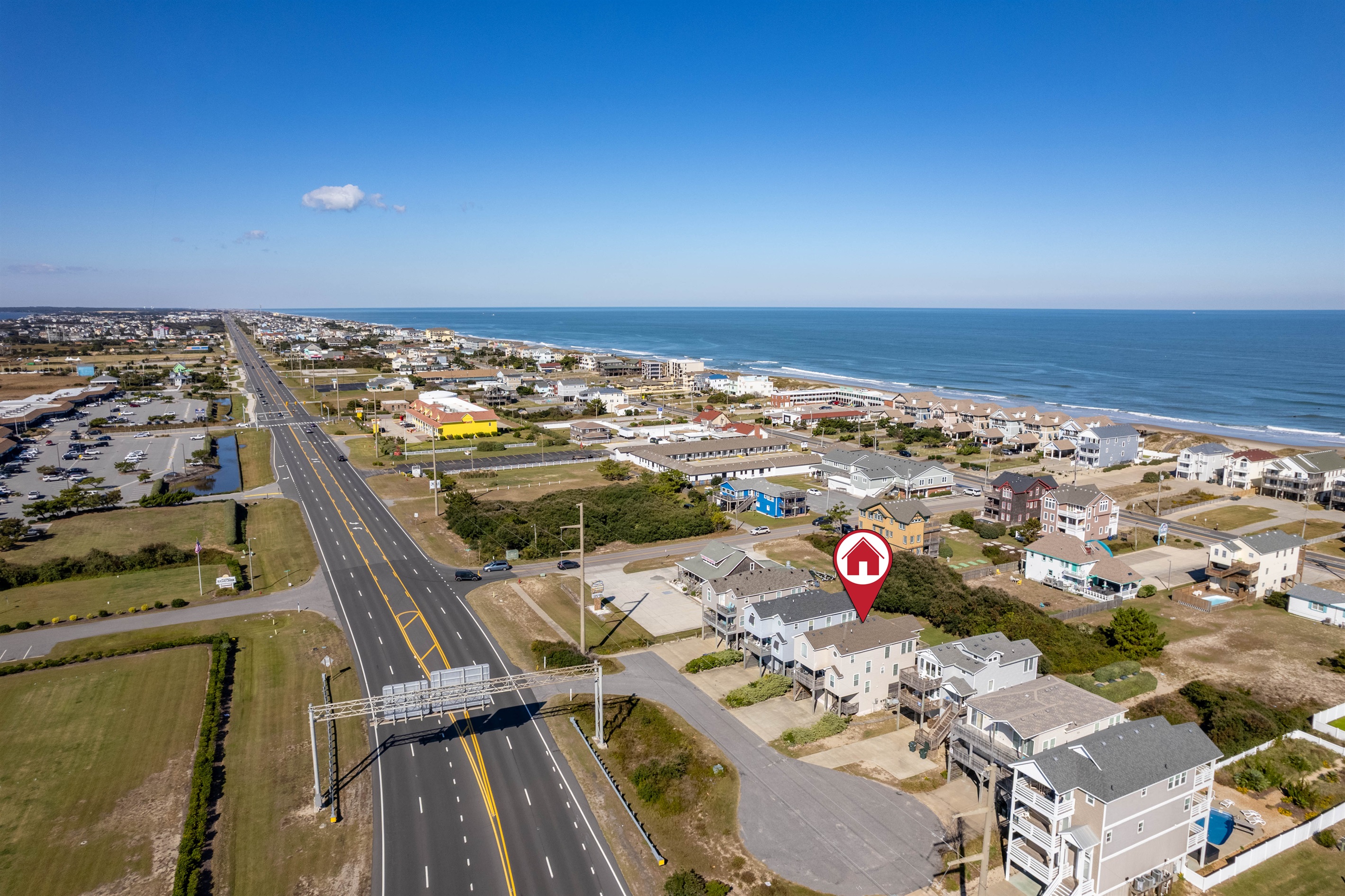 Aerial angle showing the home centered within the residential area, with the highway, beach, and local amenities all easily accessible.