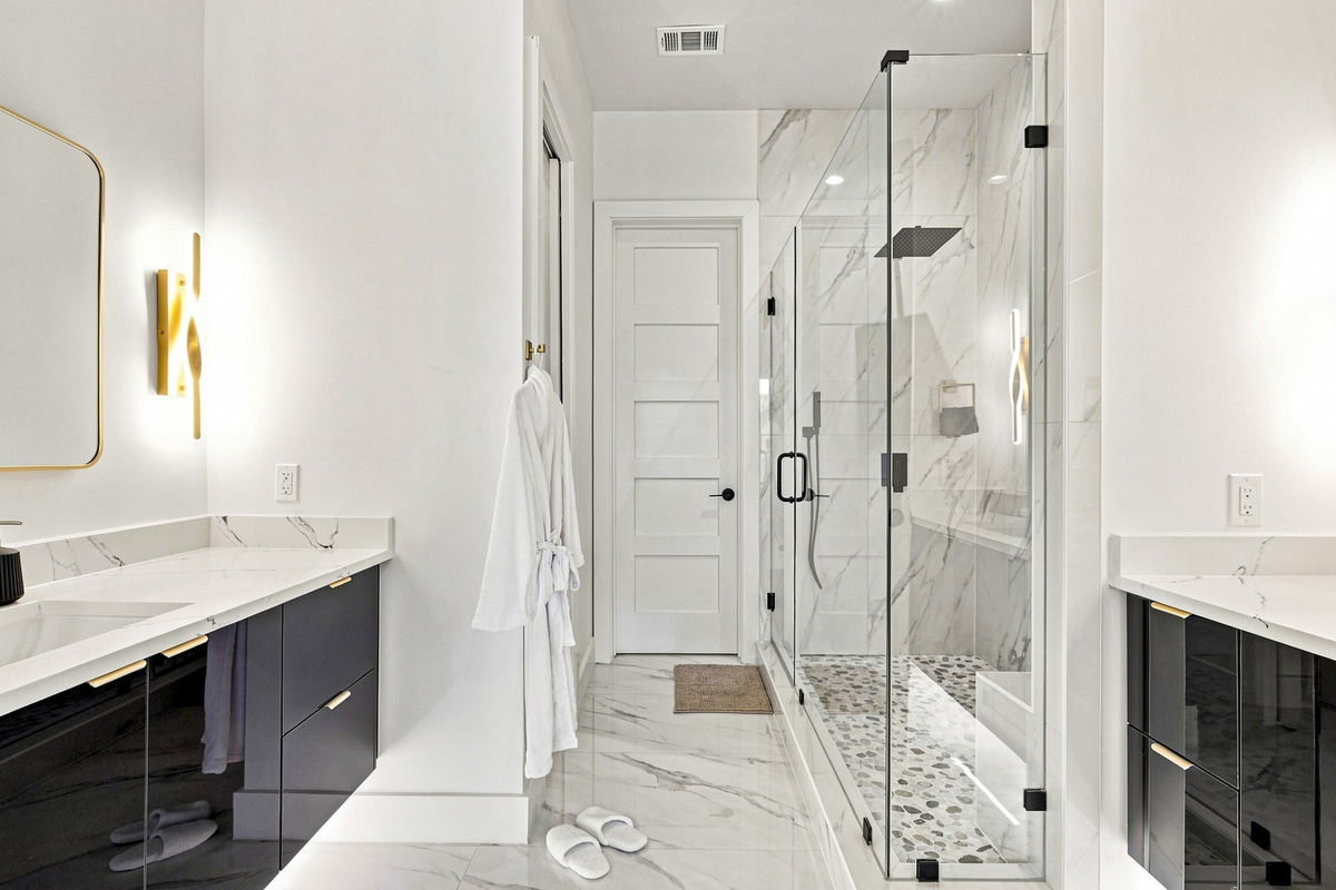 Indulge in elegance with marble finishes and a spacious, glass-enclosed shower!