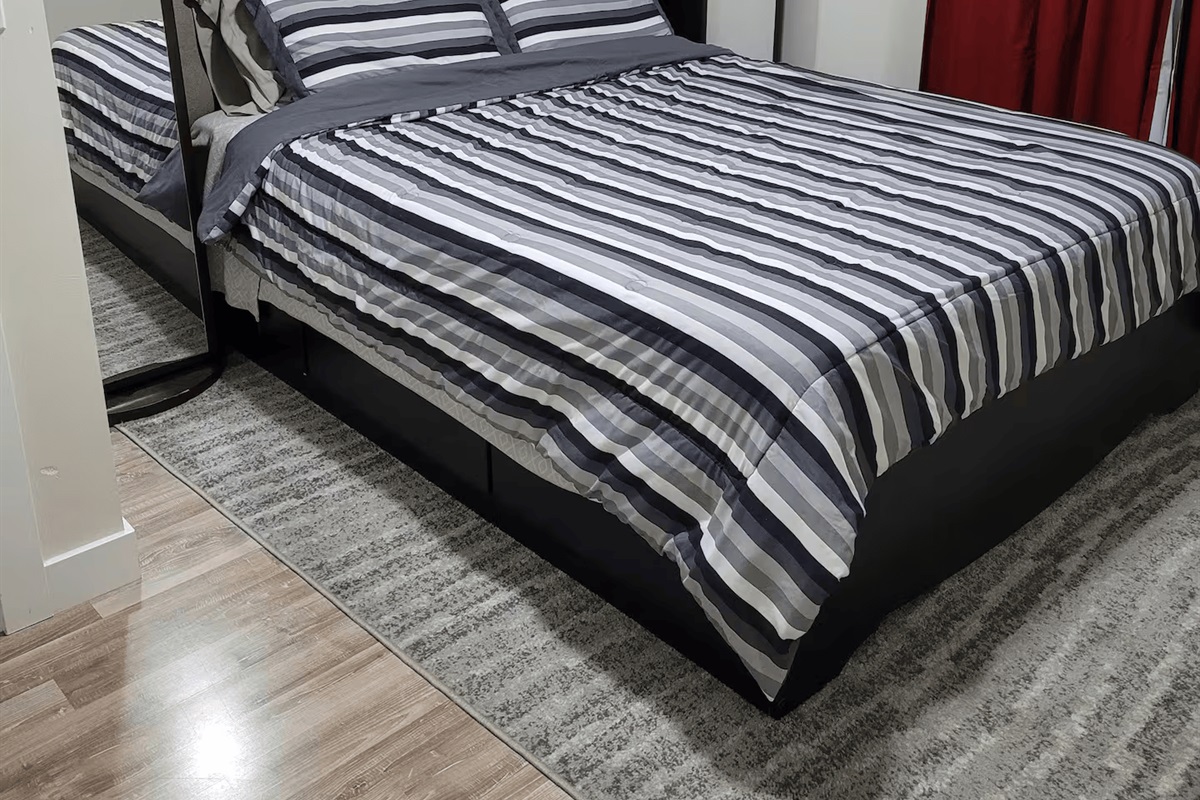 Queen size bed with drawers in the base for clothing. Two mirrored swivel shelves at each bedside with alarm clock