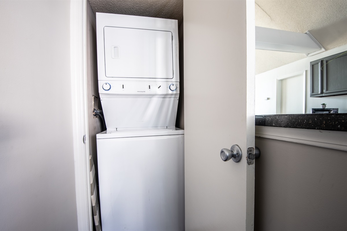 Compact washing machine in a dedicated closet next to the kitchen/bar area, ideal for quick and convenient use during your stay.