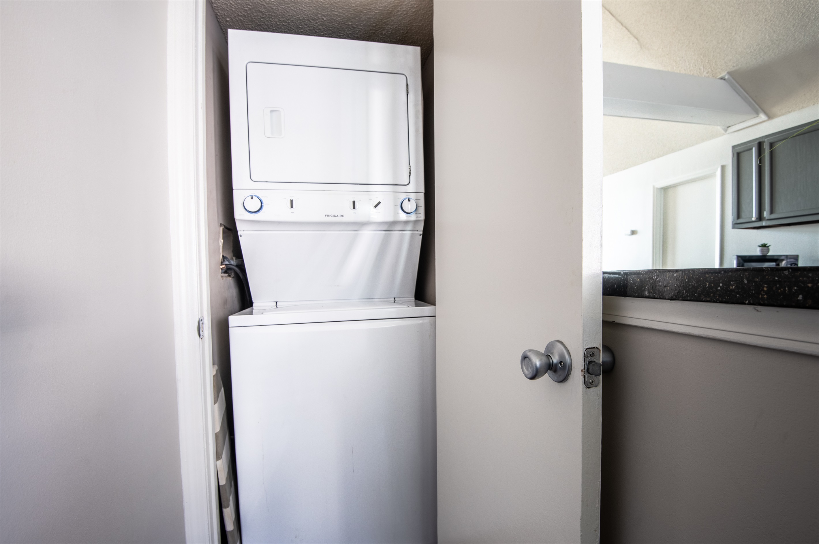 Compact washing machine in a dedicated closet next to the kitchen/bar area, ideal for quick and convenient use during your stay.