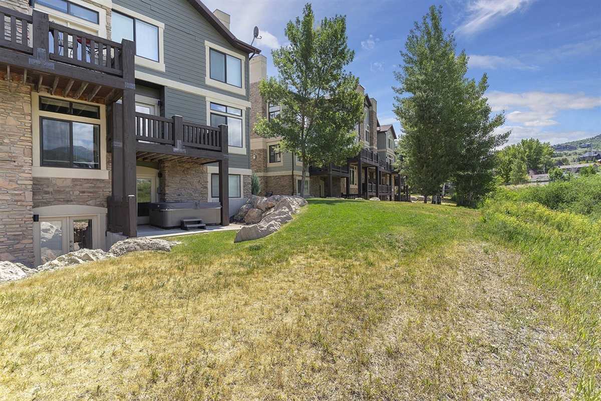 Additional exterior perspectives highlight the community’s meticulous design, with sunlit facades, mature trees, and open green areas creating a warm, upscale residential ambiance.