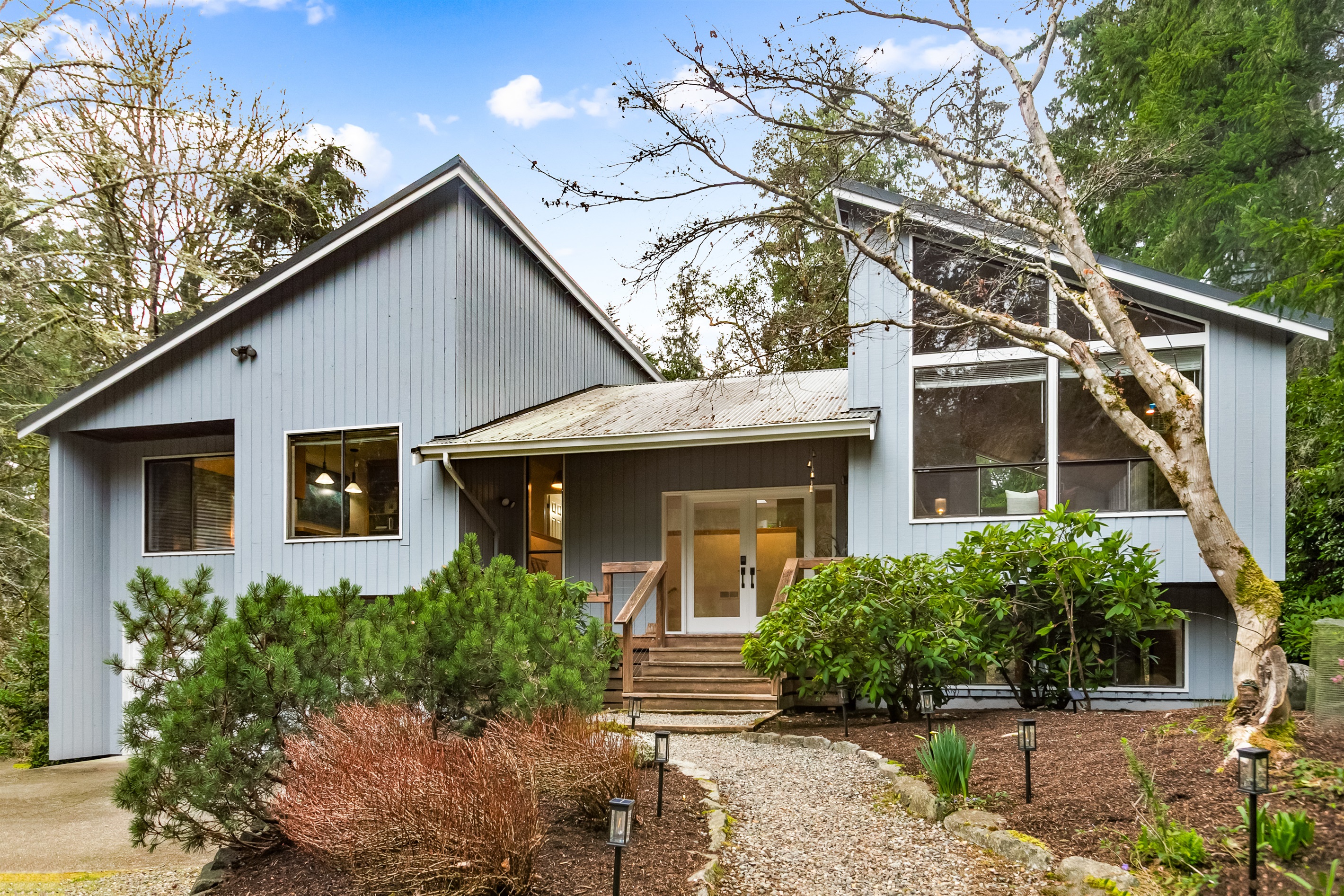 This original mid-century modern home is fully surrounded by mature trees, providing a secluded space for your retreat.