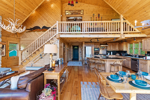 Gather together in this expansive great room featuring vaulted ceilings, rustic charm, and plenty of seating for everyone.