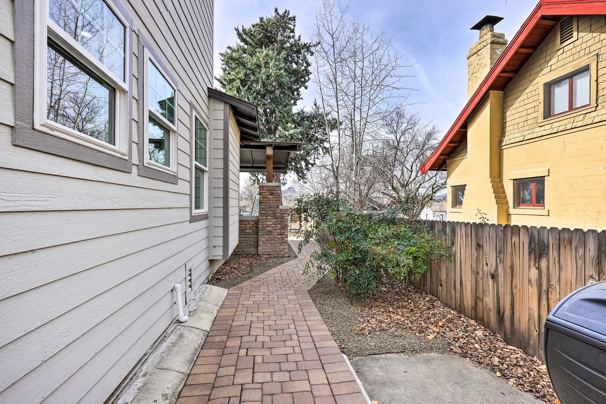 A quiet paver path winds along the side of the home, tucked beneath the trees.
