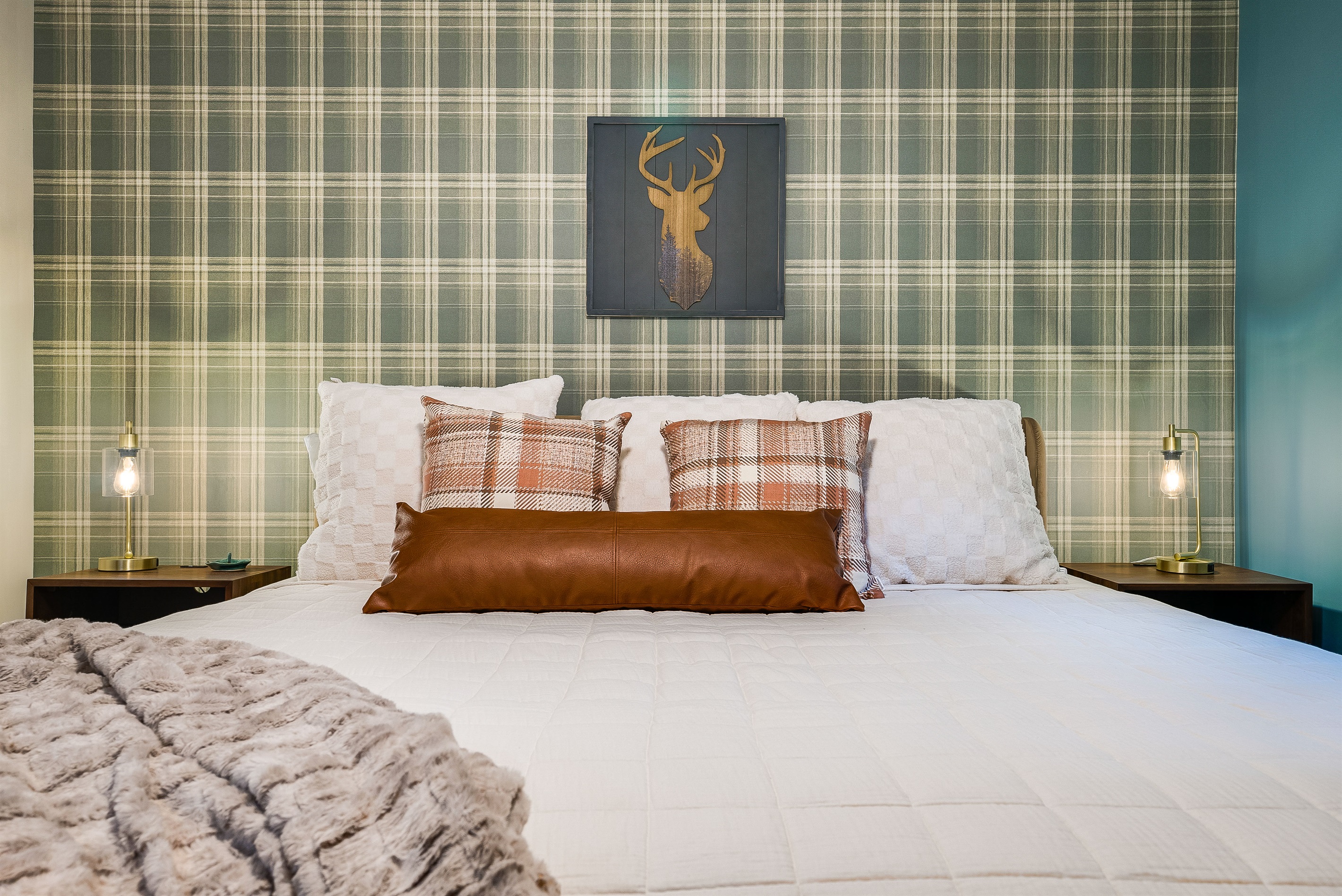 An up-close look at the plaid-accented bedroom, highlighting the mix of textures and colors—perfect for a mountain getaway with a touch of luxury.