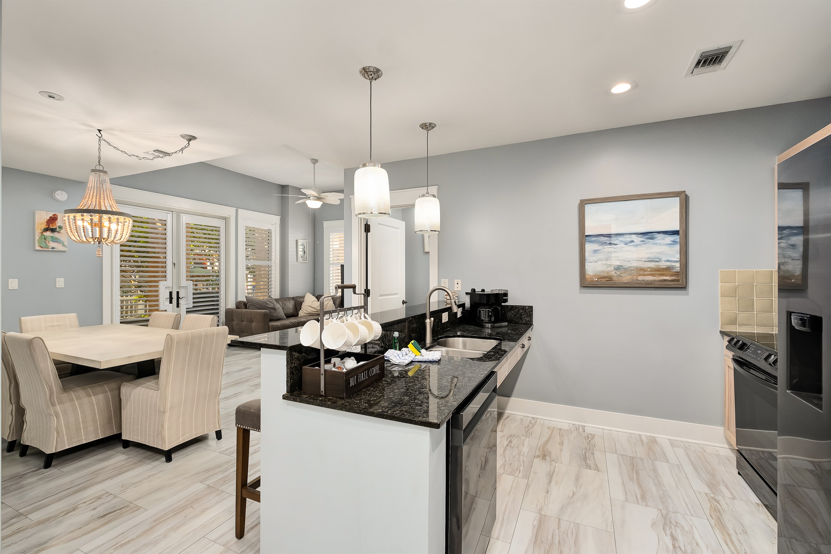 Bright and airy open-concept living area, complete with modern kitchen, granite countertops, and stylish dining space. Ideal for family meals or entertaining, all while enjoying views through the French doors to the outdoor space.