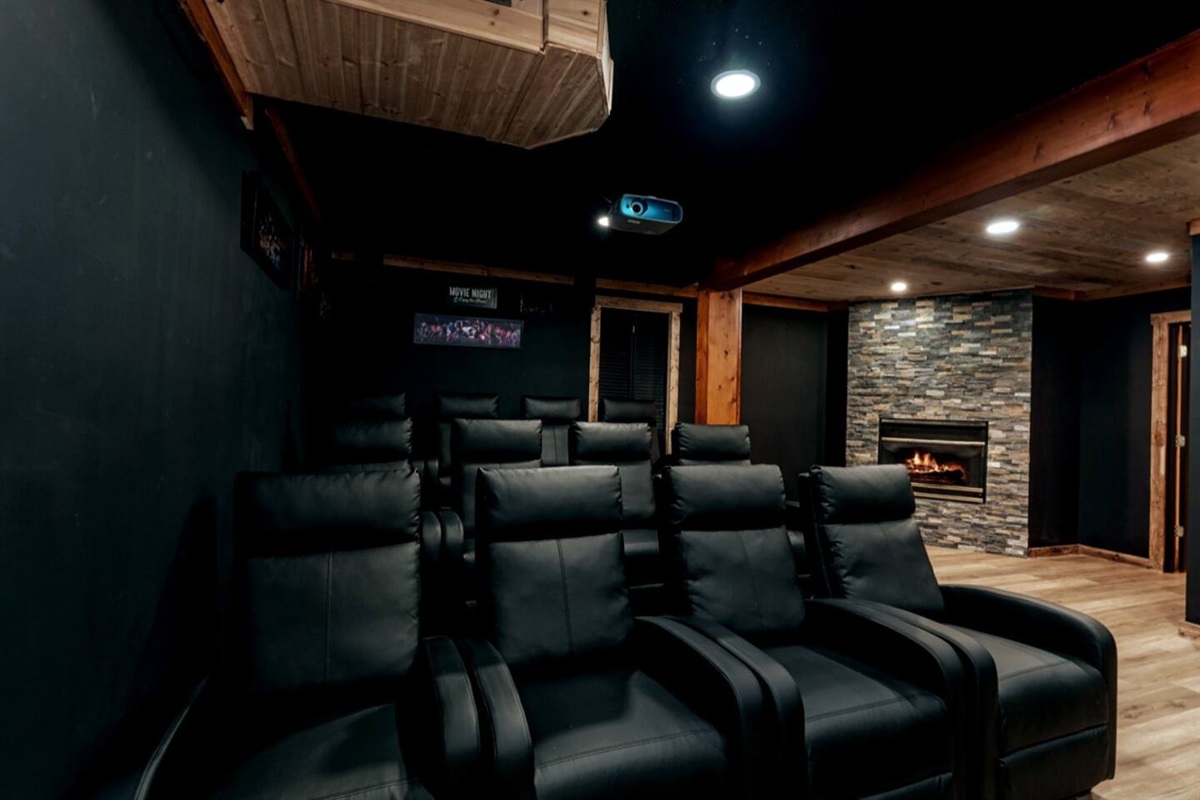 The home theater room has an extra seating area around Stone  Fire Place. 