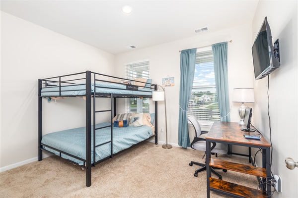 Introducing our versatile third bedroom! The highlight is a double queen bunk bed, offering ample space for guests. Accompanied by a desk and monitor, it's a multifunctional haven—whether for relaxing, working, or a mix of both. ️️‍