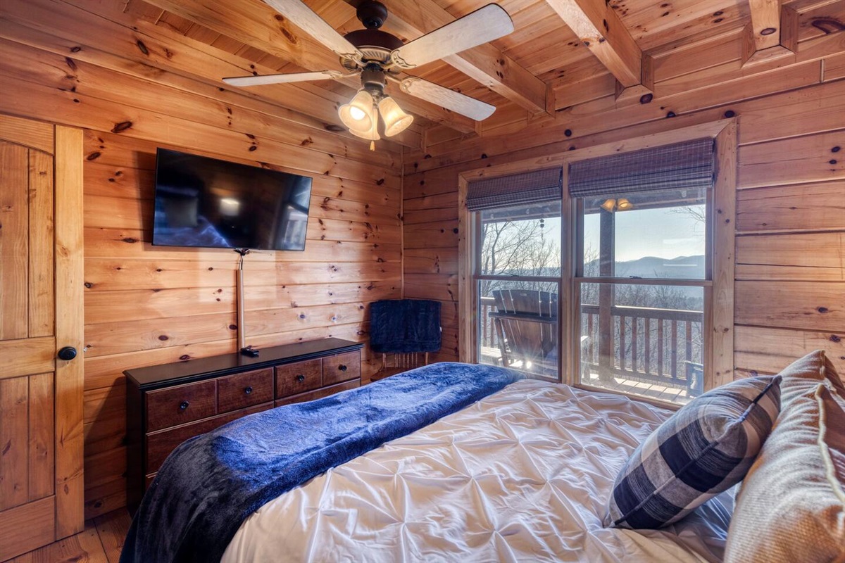 Main floor queen bedroom with TV and long range views of of mountains and sunset.