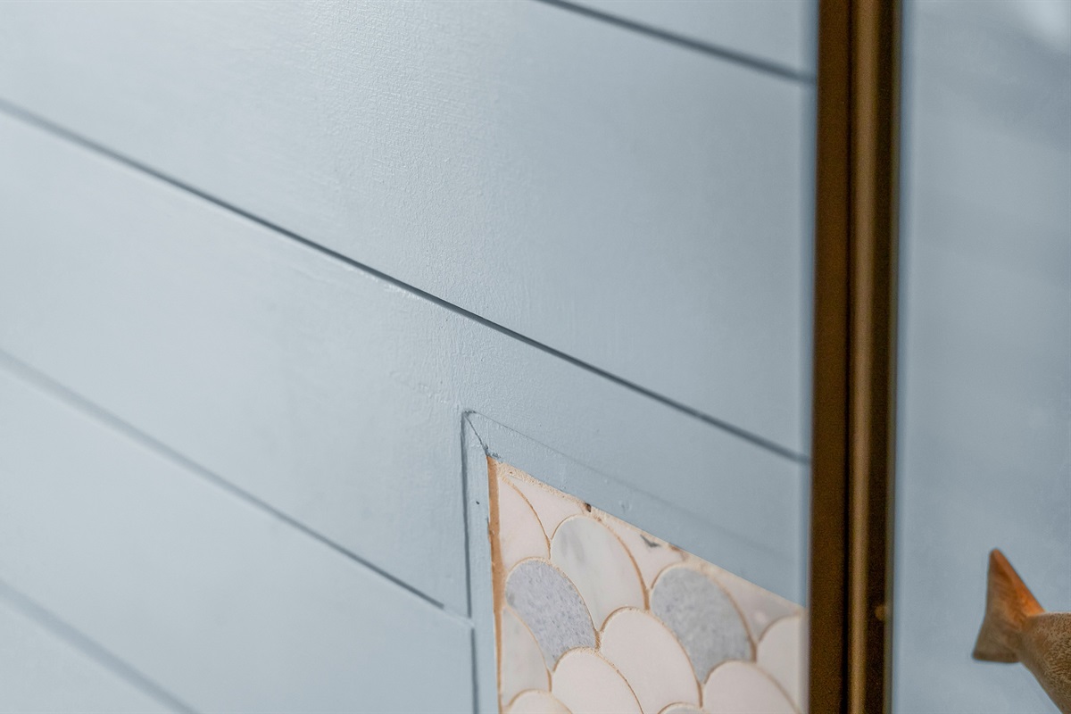 The second bathroom combines coastal charm with modern style, featuring blue shiplap walls, matt black fixtures, and a bright, airy design that brings a refreshing spa-like feel to the space