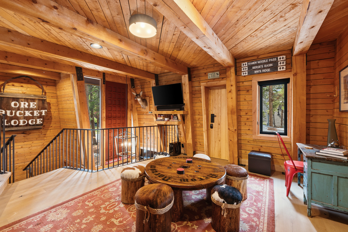 Multi-function second living area on upper level with game table, desk, tv, and bathroom. 