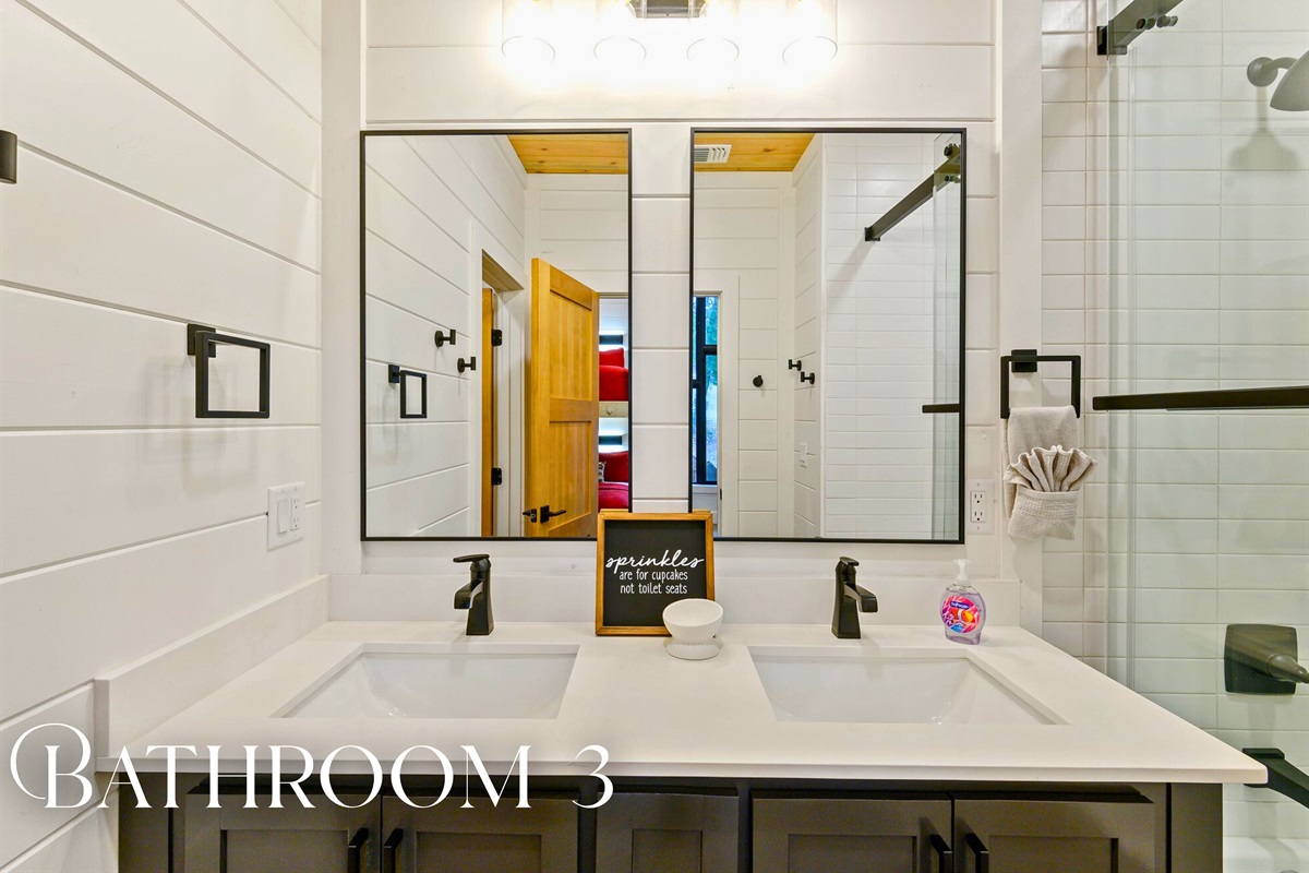 A third bathroom with charming details and thoughtful touches—including double sinks and soft lighting.