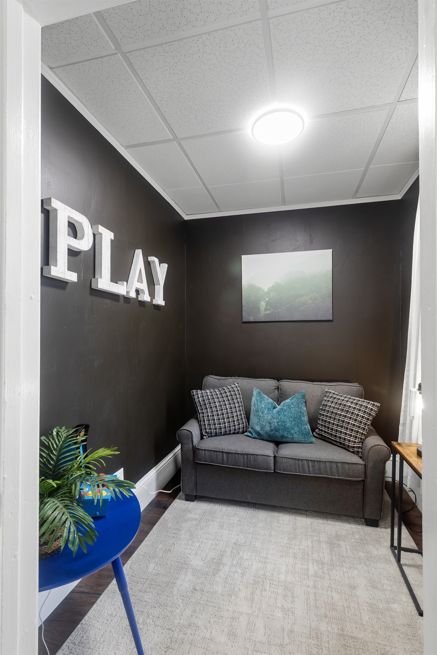 The play room doubles as a cozy lounge with a comfy loveseat and retro gaming
