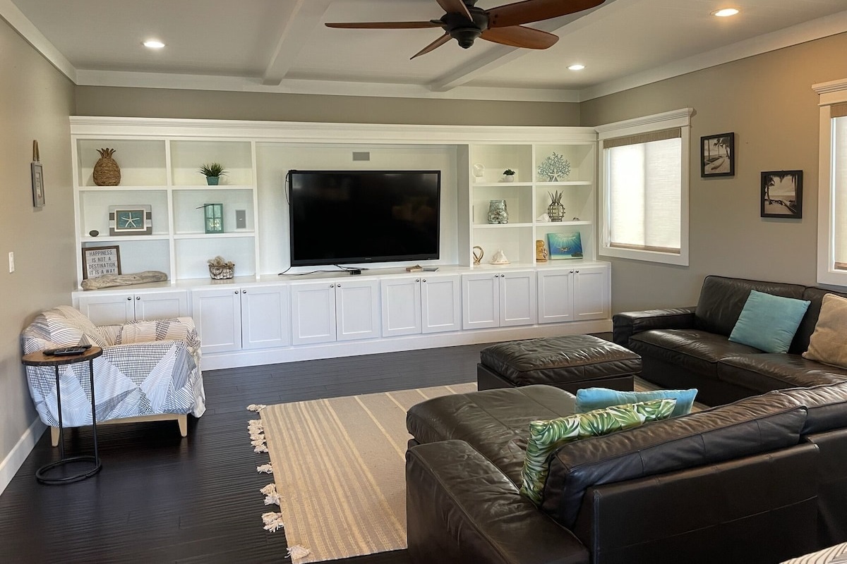 Living room with big leather couch and 70" TV