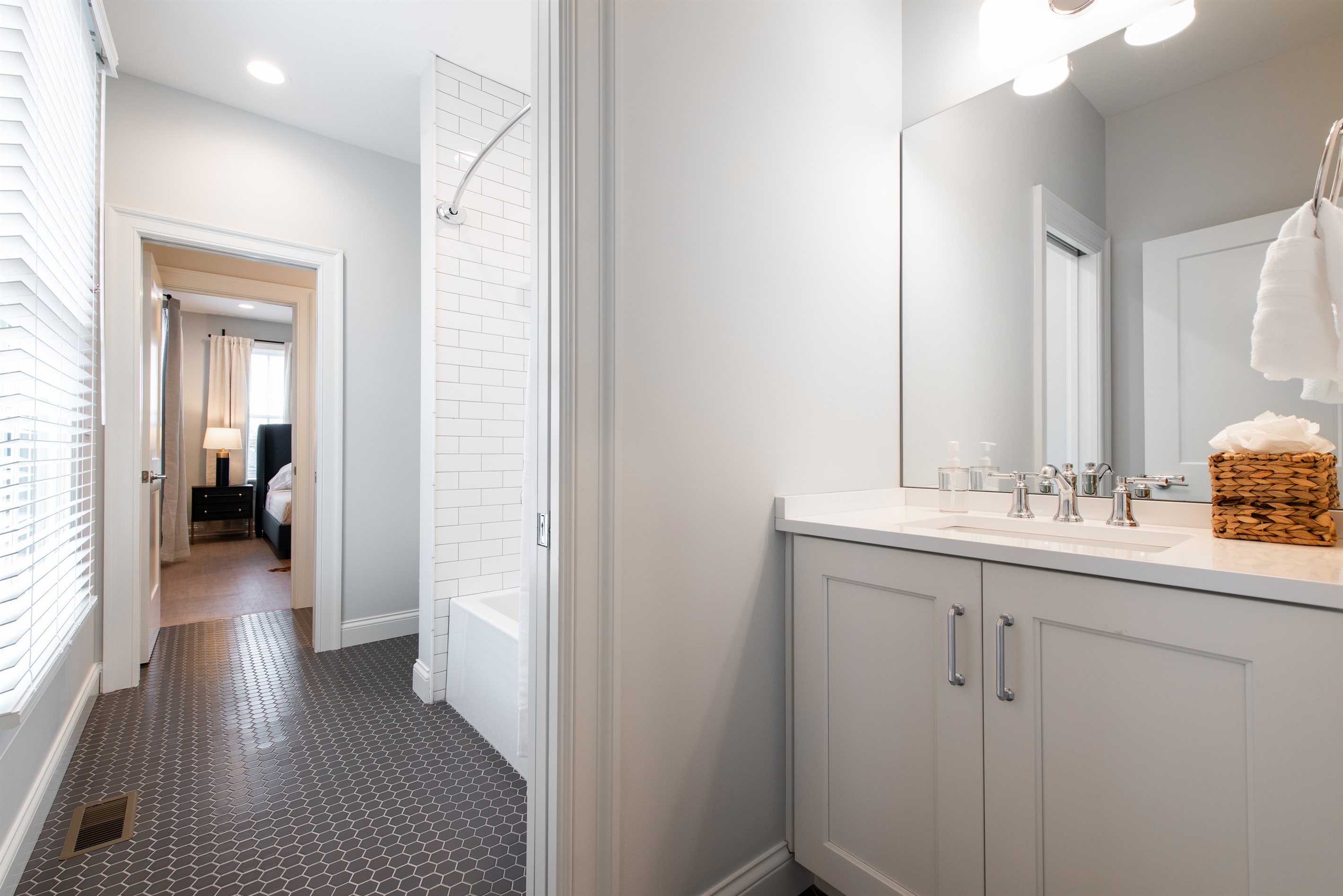 Step into comfort with this modern bathroom featuring a sleek vanity, bright lighting, and a stylish tiled floor. The open layout leads directly to the bedroom, offering convenience and elegance for your stay on the Bourbon Trail.