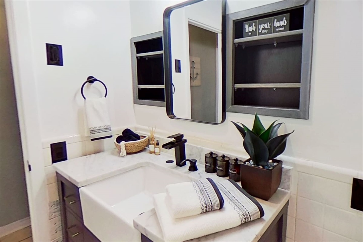 Bathroom Vanity, with plenty of shelf and cabinet storage. We provide Plush Towels, Hand & Makeup Towels, Washcloths, and basic toiletries (Shampoo, Conditioner, Body Wash, Hand Soap, Qtips, Cotton Balls) 