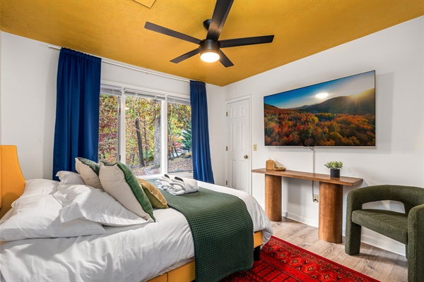 Curl up in this cozy bedroom with nature views and a big-screen TV for late-night unwinding.