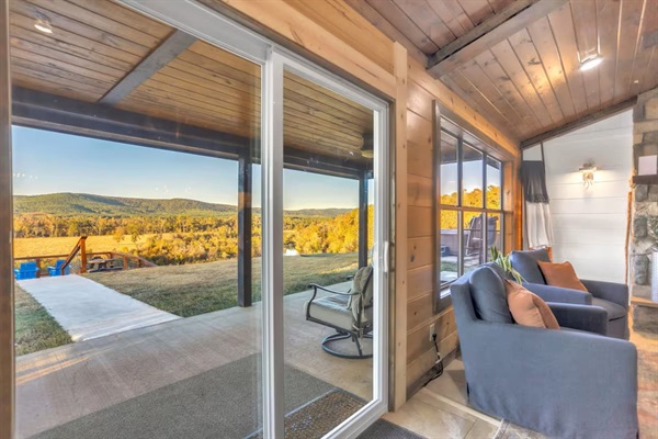 Indoor-outdoor living with sliding glass doors opening to mountain and valley views.
