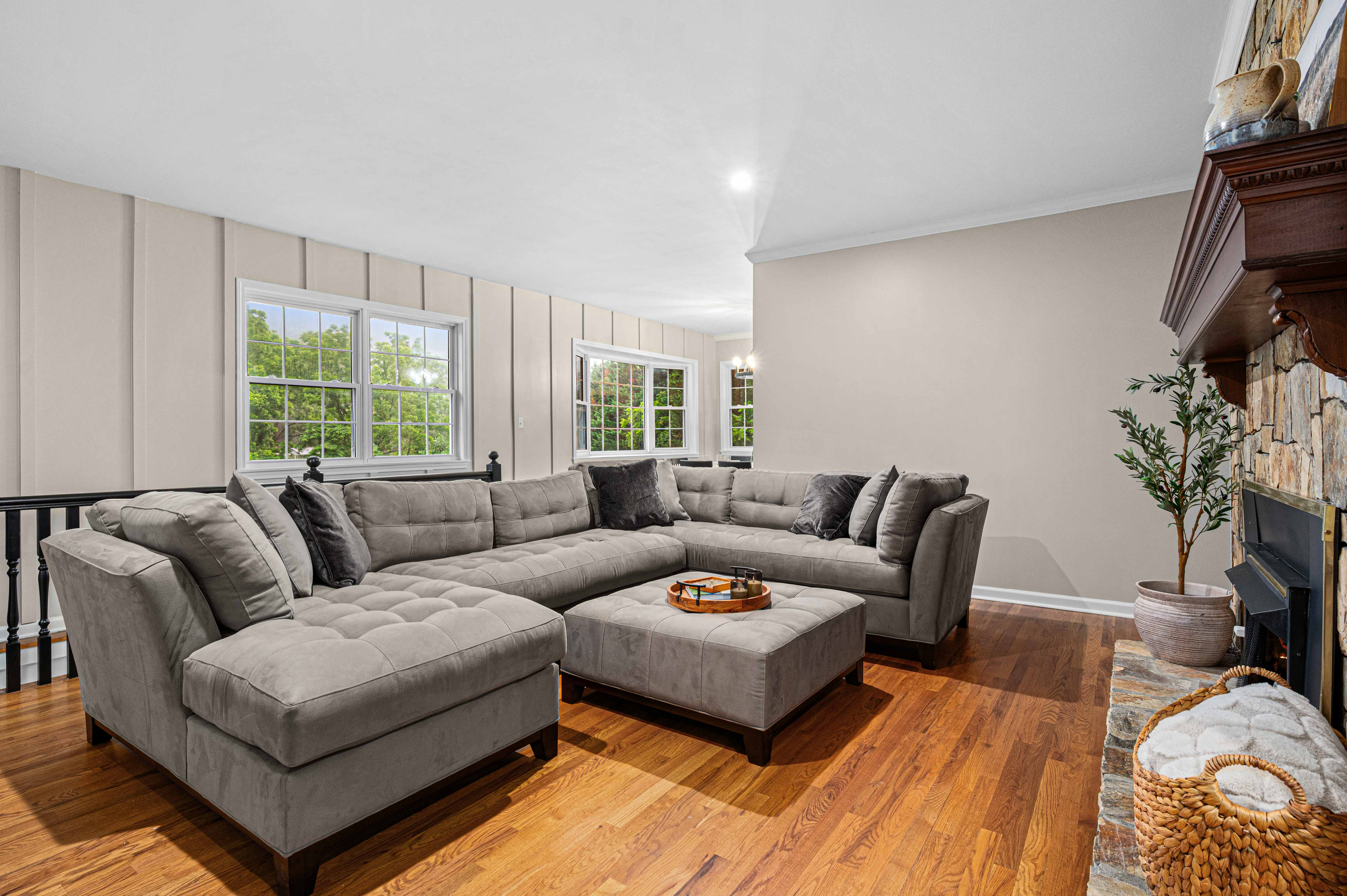 Living Room Retreat: Spacious sectional sofa invites relaxation while sunlight pours in through the windows!
