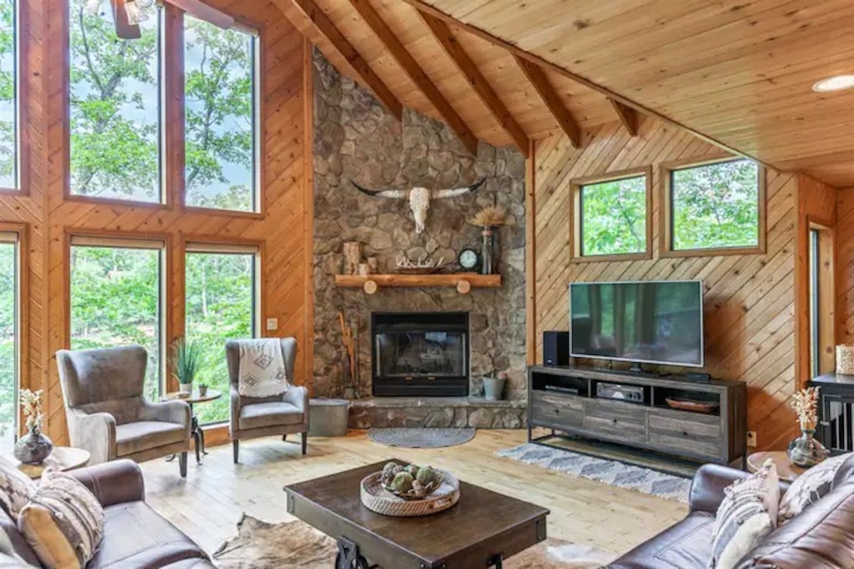 Cozy living room with stone fireplace & lake views