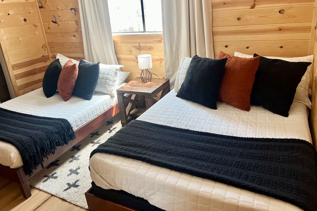 Three of 5 bedrooms pictured, featuring two full-sized beds (sleeps up to 4 people). This room has a Roku streaming TV.