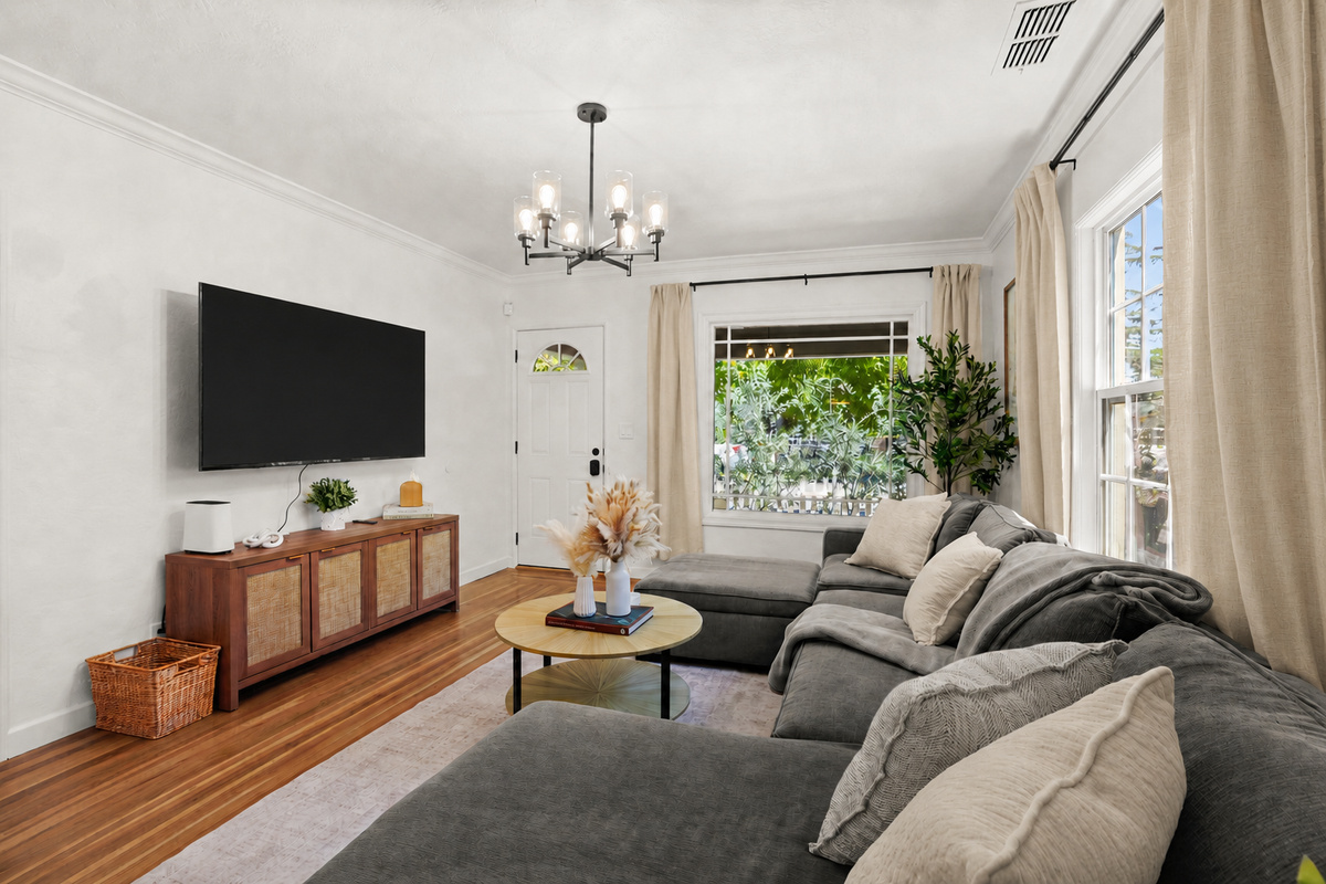 Bright, inviting living room with cozy seating, modern decor, natural light, and a Smart TV for relaxing nights in.