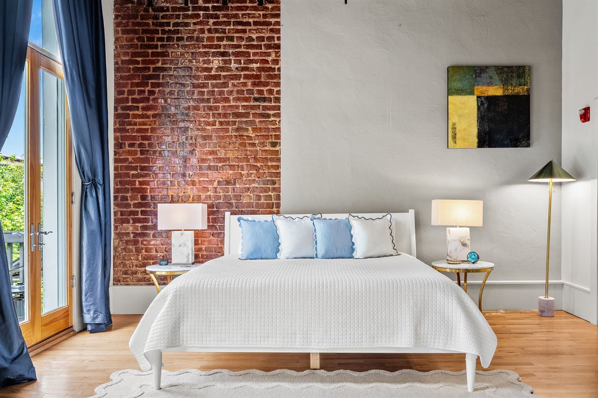 Master bedroom with king bed, private balcony, lounge seating, and ensuite bathroom.