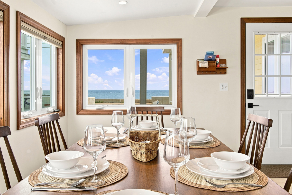 Bright dining area with seating for six and beautiful ocean views through large picture windows.