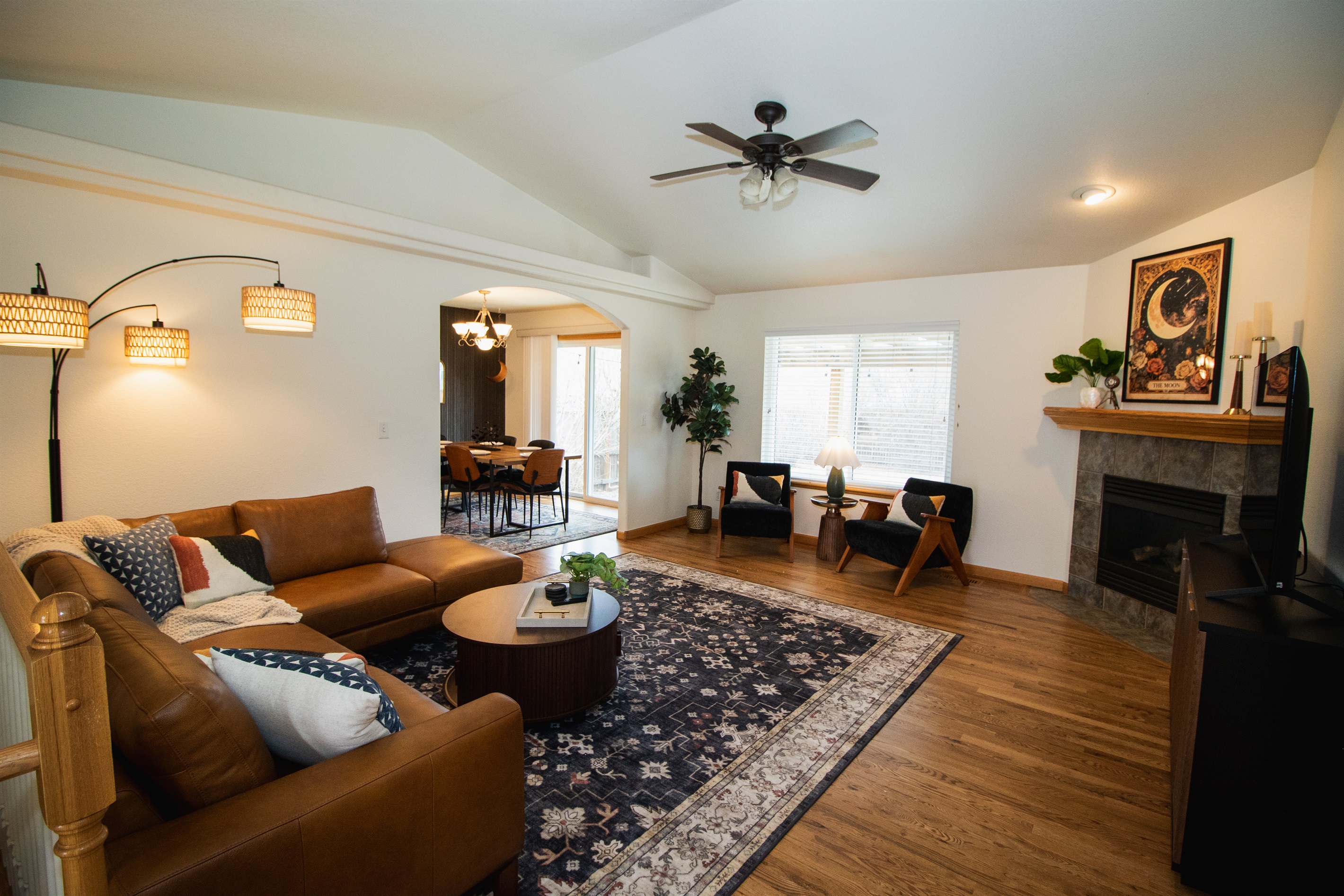 Enjoy a spacious and warm living area with high-ceilings, moody finishes, smart tv, and comfortable seating