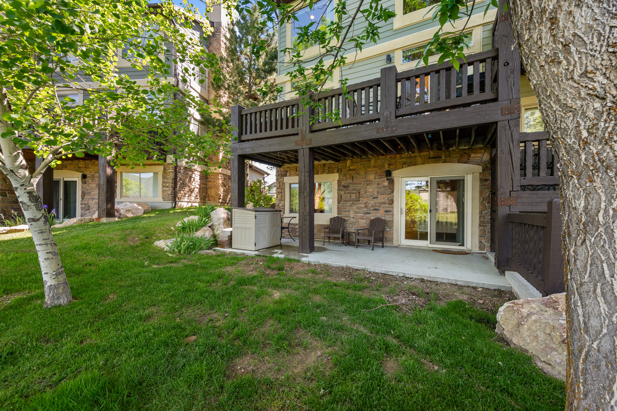 Ground-level patio area surrounded by mature trees and green space, offering a peaceful outdoor setting to relax and enjoy the beauty of Lakeside Village.