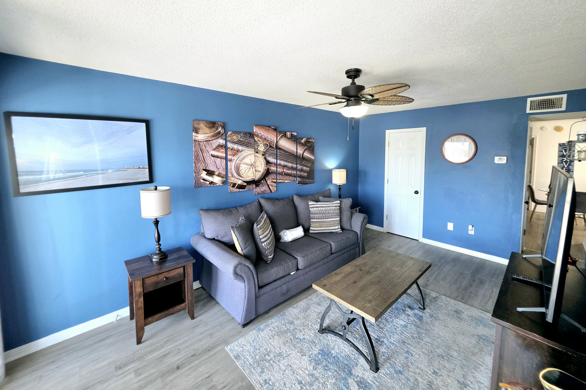 Nest side – Living room with sofa, coffee table and nautical wall art