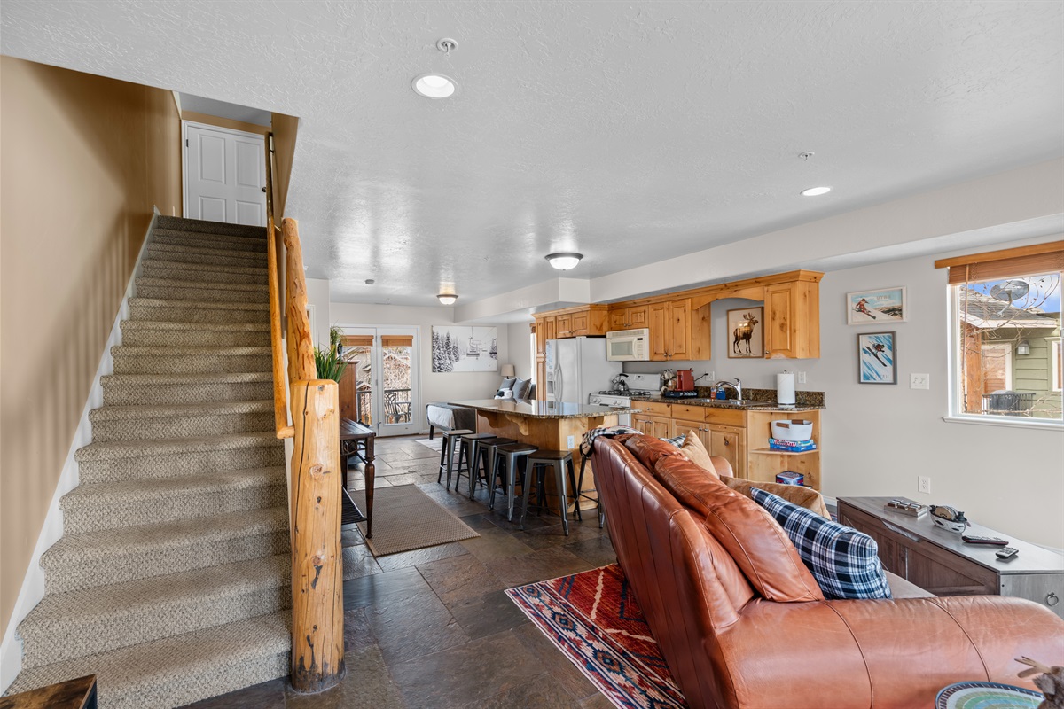 Spacious view showing seamless flow between living, kitchen, and stairs.