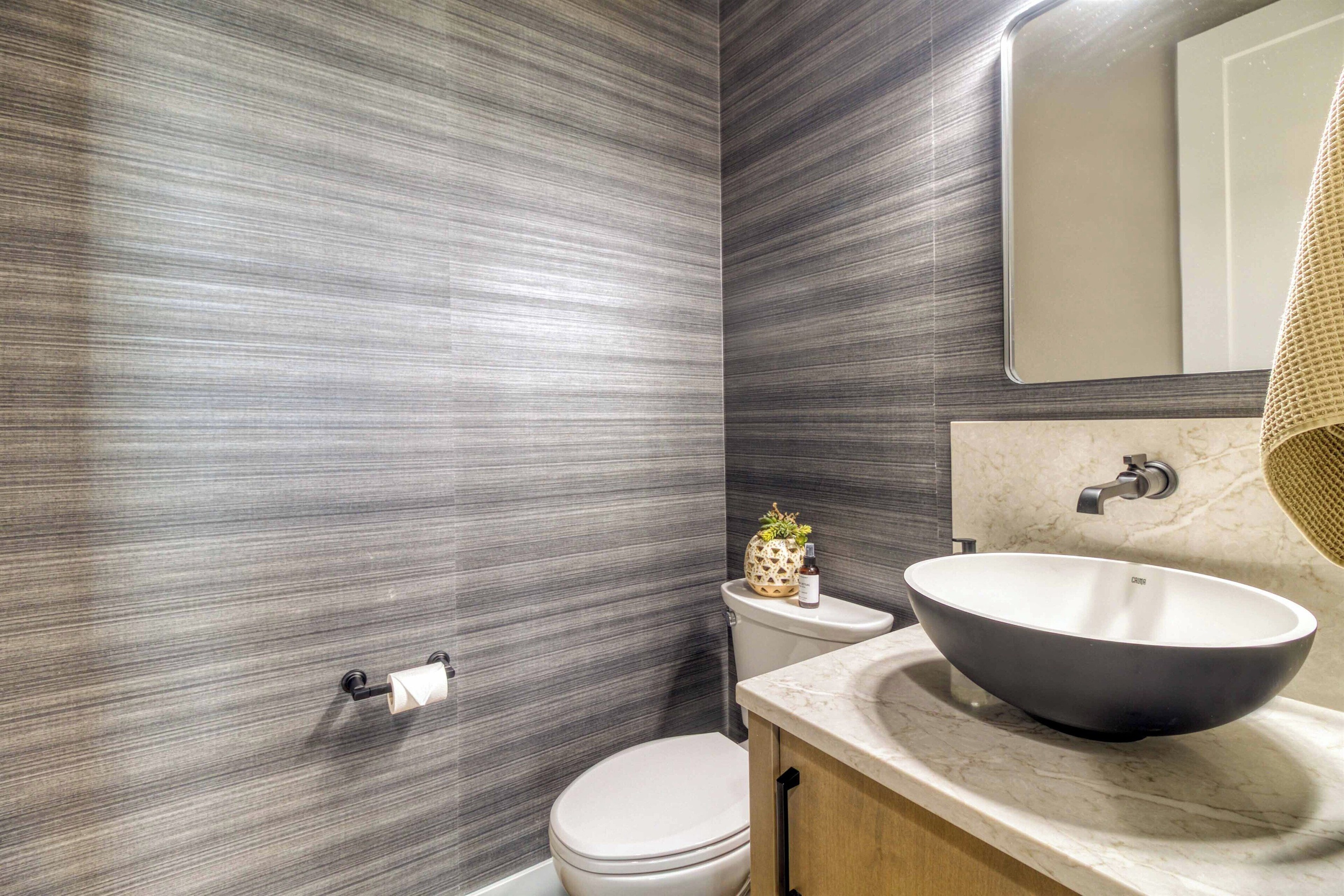 Half bath with vessel sink & dramatic wallpaper.