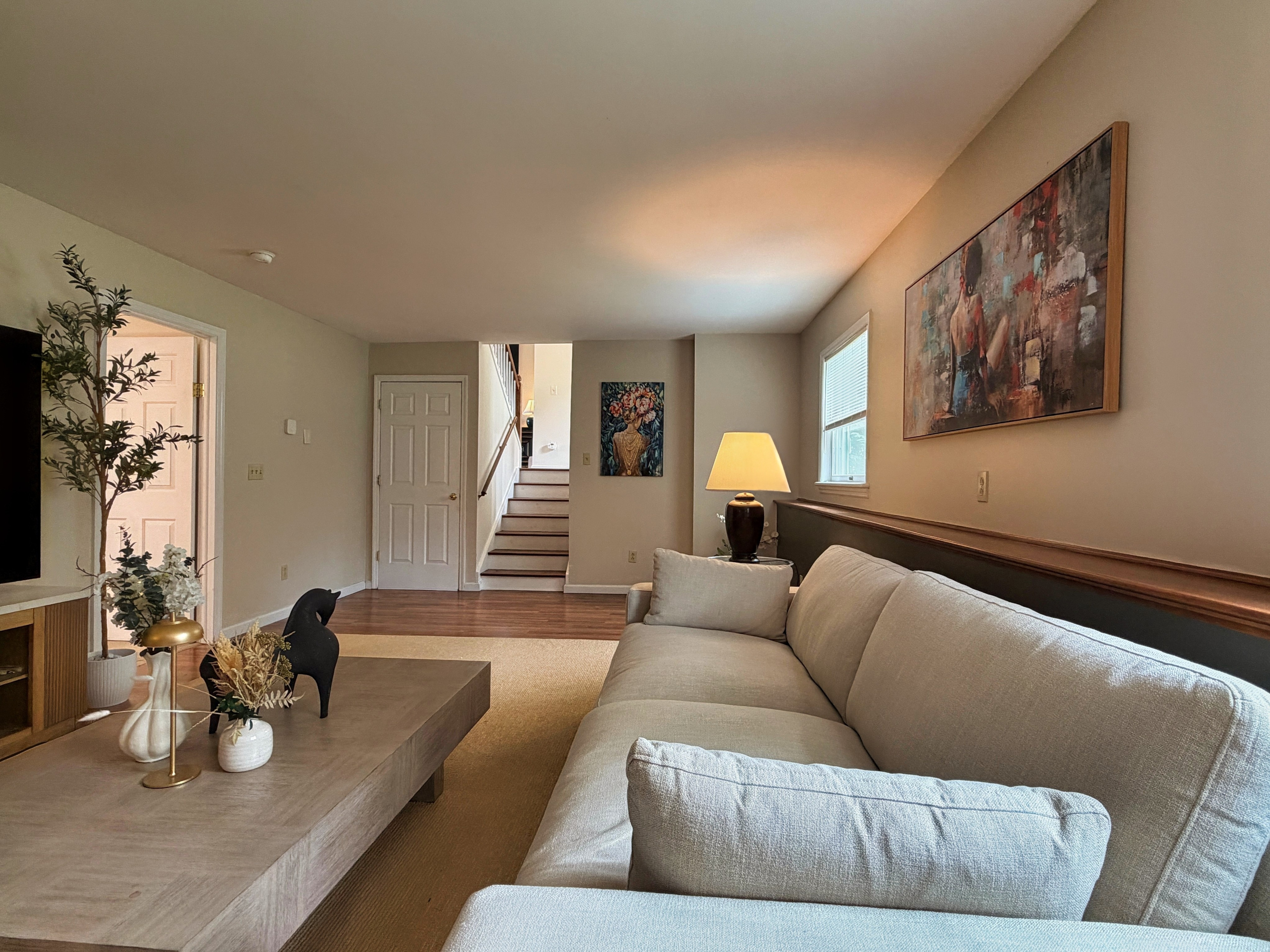 Lower level living room with view of the stairs from the 1st floor