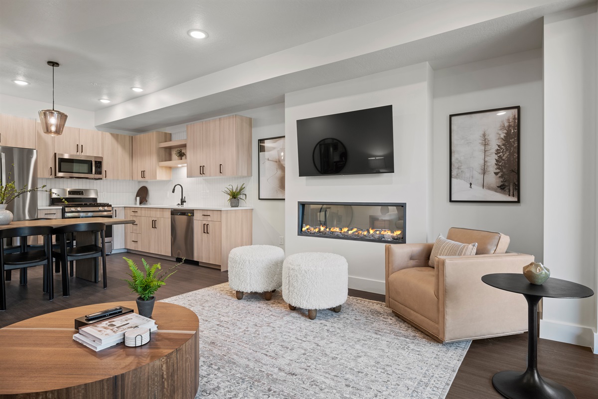 The living room, has a smart TV, electric fireplace, and modern decor.