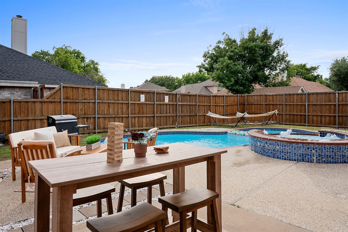 Enjoying the perfect blend of relaxation and nature in this outdoor seating area near the pool and hot tub in the backyard.